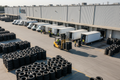 Multiple cargo vans and box trucks loaded with stacked tires at a warehouse dock - Ziggy Zion Transport bulk delivery service